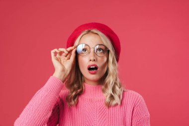 Şok olmuş güzel kız gözlüklü ve yukarı bakan pembe arka plan