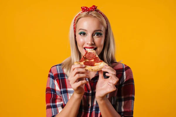 照片中快乐迷人的女孩一边吃着黄底披萨一边微笑 — 图库照片