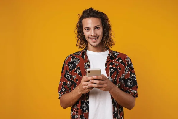 照片中快乐的年轻人使用手机 在黄色背景下面带微笑 — 图库照片
