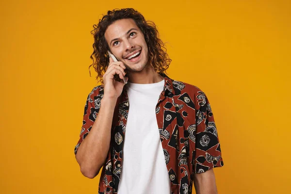 Photo Happy Curly Guy Smiling While Talking Cellphone Isolated Yellow — Stock fotografie