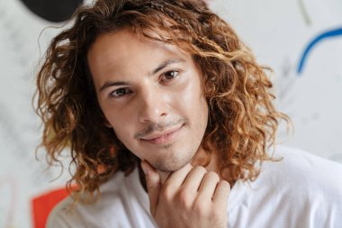 Beyaz, yakışıklı, mutlu adam gülümseyen ve kapalı alanda kameraya bakan.