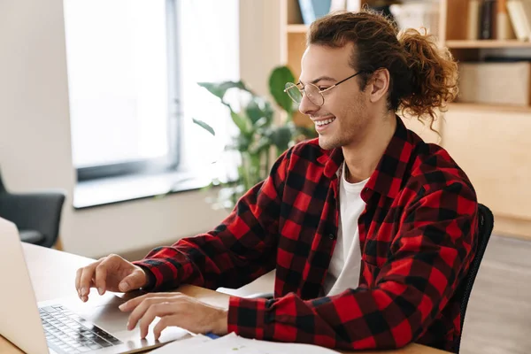 Красивий Усміхнений Хлопець Окулярах Працює Ноутбуком Сидячи Офісі — стокове фото