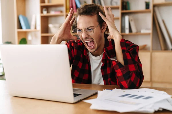 Przystojny Irytujący Facet Okularach Krzyczy Podczas Pracy Laptopem Biurze — Zdjęcie stockowe