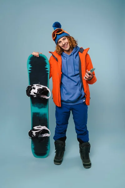 Guapo Deportista Feliz Posando Con Teléfono Celular Snowboard Aislado Sobre — Foto de Stock
