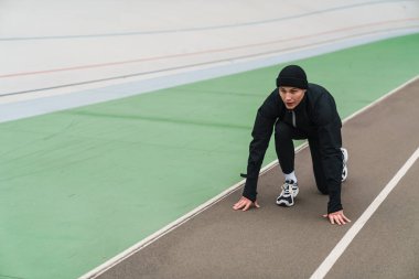 Genç atletik adam dışarıda stadyumda çalışırken egzersiz yapıyor.
