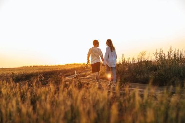 Dışarıda köpekle gezen genç bir çiftin görüntüsü.