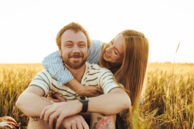 Sahada kucaklaşan mutlu, genç bir çiftin görüntüsü.
