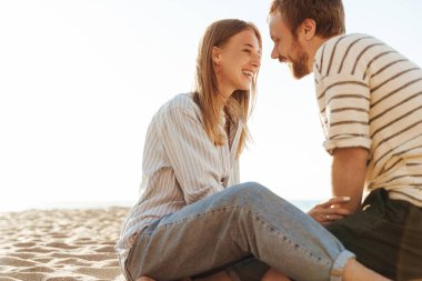 Sahilde oturan mutlu bir çiftin resmi.