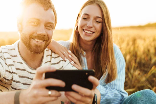 Bild Eines Jungen Gut Gelaunten Liebespaares Das Sein Handy Draußen — Stockfoto