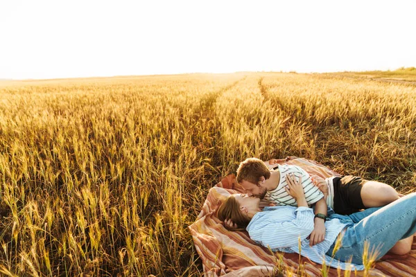 Foto Una Joven Pareja Cariñosa Besándose Tendidos Juntos Afuera Campo —  Fotos de Stock