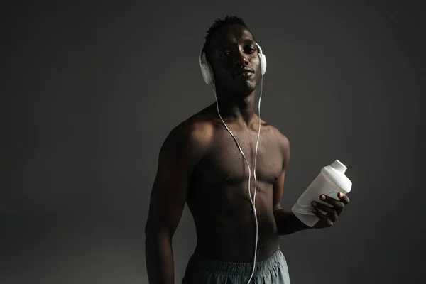 Hemdloser Afrikanisch Amerikanischer Sportler Mit Kopfhörern Während Wasser Isoliert Vor — Stockfoto