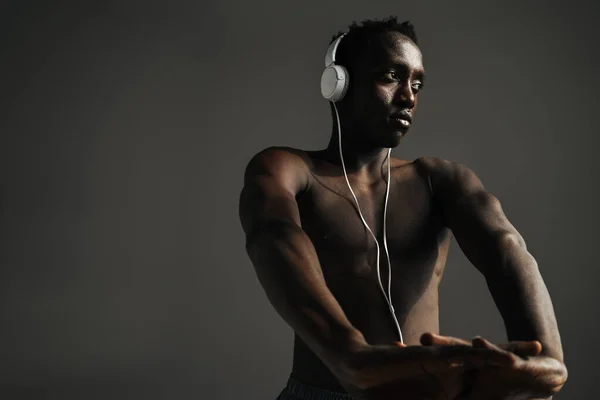 Shirtless African American Sportsman Using Headphones While Stretching His Hands — Stock Photo, Image