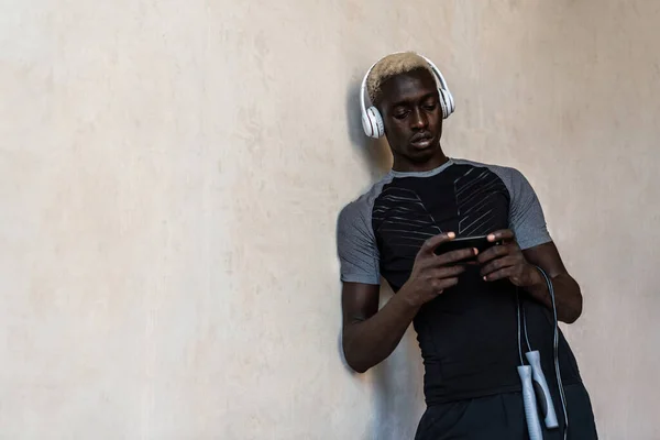 Молодой Африканский Американец Наушниках Держа Скакалку Сотовый Телефон Стоя Над — стоковое фото