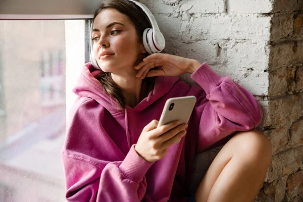 Mujer Joven Enfocada Los Auriculares Usando Teléfono Celular Mientras Está — Foto de Stock