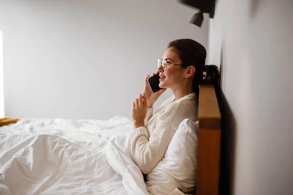 Beautiful Joyful Girl Talking Cell Phone Smiling While Sitting Bad — стоковое фото