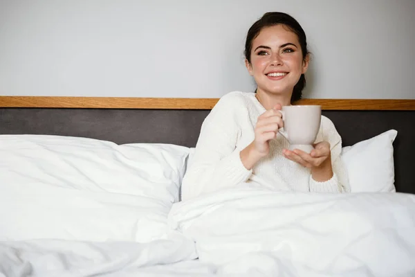 Charming Cheerful Girl Smiling Drinking Coffee While Sitting Bad Home — Stock Photo, Image