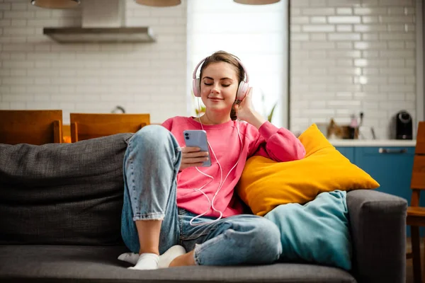 Ωραίο Χαρούμενο Κορίτσι Ακούει Μουσική Ακουστικά Και Κινητό Ενώ Κάθεται — Φωτογραφία Αρχείου
