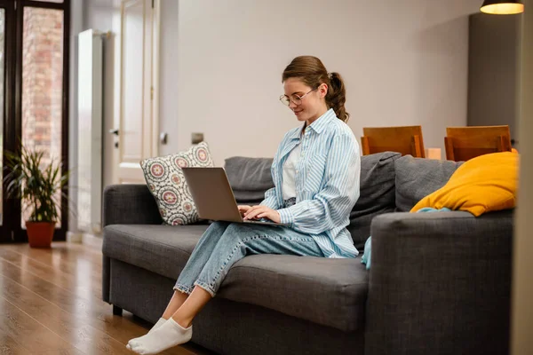 Schöne Lächelnde Mädchen Die Mit Laptop Arbeiten Während Sie Hause — Stockfoto