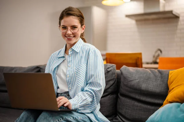 Hermosa Chica Sonriente Trabajando Con Ordenador Portátil Mientras Está Sentado — Foto de Stock