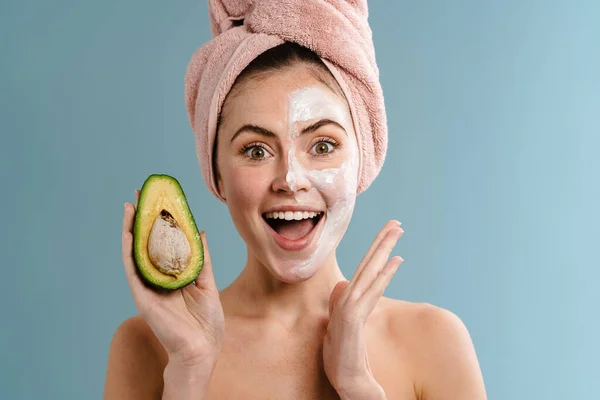 Shirtless Excited Girl Nourishing Mask Holding Avocado Isolated Blue Background — Stock Photo, Image