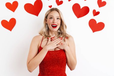 Kırmızı elbiseli, beyaz arka planda kalbi olan kırmızı rujlu, şaşırmış genç bir kadının görüntüsü.