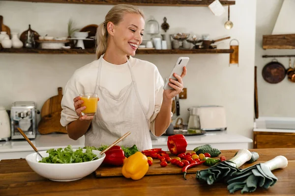 Gyönyörű Boldog Használja Mobiltelefon Ivólé Miközben Ebéd Hangulatos Konyhában — Stock Fotó