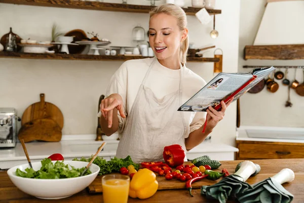 Güzel Neşeli Bir Kadın Yemek Kitabı Okuyor Yemek Yaparken Gülümsüyor — Stok fotoğraf