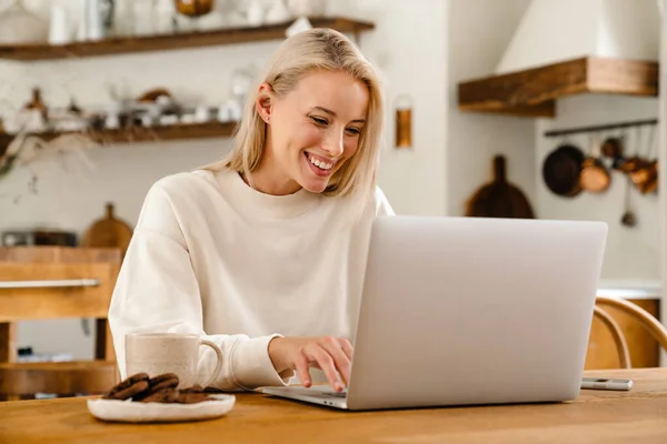 Mulher Feliz Bonita Bebendo Chá Enquanto Trabalhava Com Laptop Cozinha — Fotografia de Stock