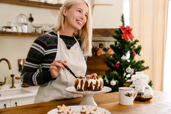 Mutfakta Noel Pastası Yerken Önlüklü Mutlu Güzel Kız Gülümsüyor — Stok fotoğraf