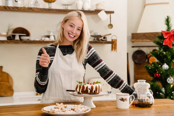 Mutfakta Noel Pastası Yerken Önlüklü Mutlu Bir Kız Baş Parmağını — Stok fotoğraf