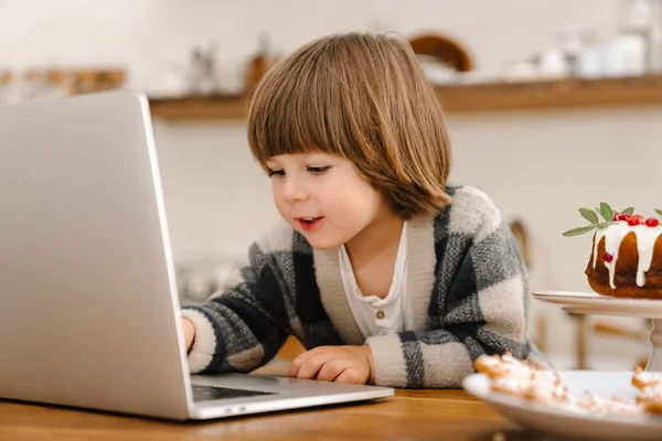 Pleased Beautiful Boy Using Laptop While Sitting Home Kitchen — Stock Photo, Image