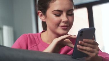 Evde cep telefonu kullanan mutlu iyimser genç kız.