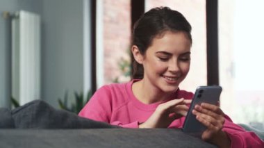 Evde cep telefonu kullanan genç pozitif bir kız.