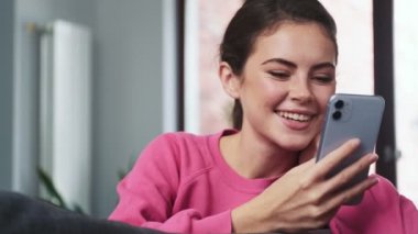 Evde cep telefonu kullanan mutlu genç kız.