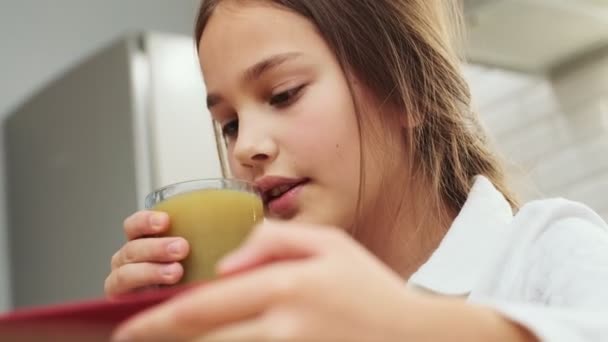Menina Agradável Criança Tomando Café Manhã Dentro Casa Enquanto Assiste — Vídeo de Stock