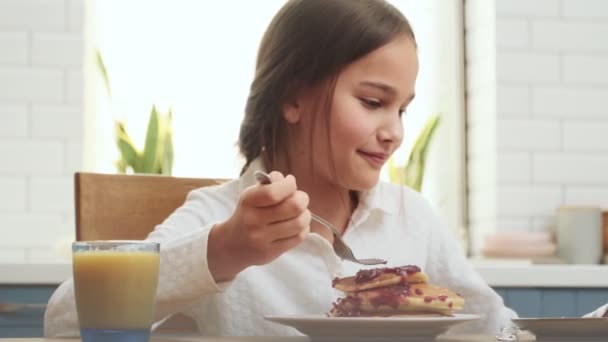 Positives Mädchen Kind Frühstückt Hause Während Sich Videos Handy Ansieht — Stockvideo