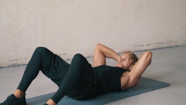 Ένας Εστιασμένος Άντρας Κάνει Ασκήσεις Ξαπλωμένος Στο Στρώμα Της Γιόγκα — Αρχείο Βίντεο