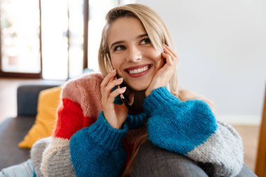 Çekici, gülümseyen, cep telefonu kullanan genç bir kadın.