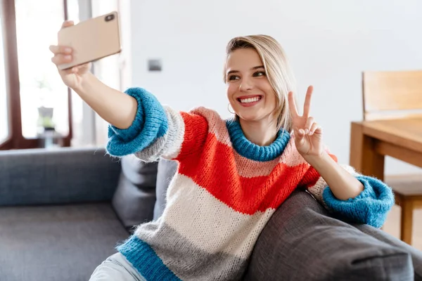 Mutlu Genç Bir Kadın Evdeki Kanepede Otururken Selfie Çekiyor — Stok fotoğraf