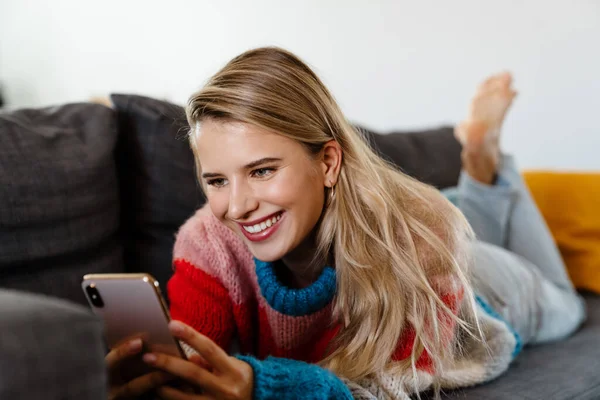 Attractive Smiling Young Woman Using Mobile Phone While Ralaxing Couch — Stock Photo, Image