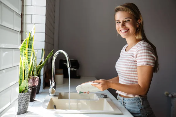 Mooie Glimlachende Jonge Vrouw Wast Afwas Tijdens Het Schoonmaken Keuken — Stockfoto