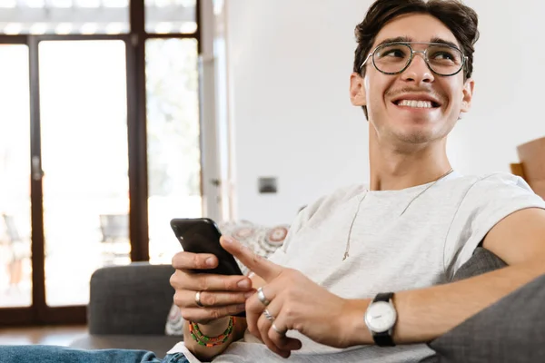 Immagine Felice Uomo Ottimista Seduto Sul Divano Casa Mentre Utilizza — Foto Stock