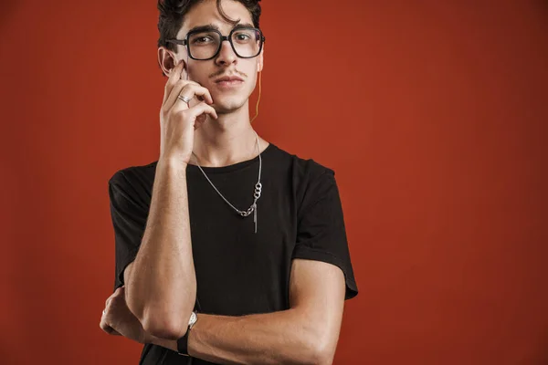 Pensive Jonge Hipster Tiener Glazen Geïsoleerd Een Rode Achtergrond — Stockfoto