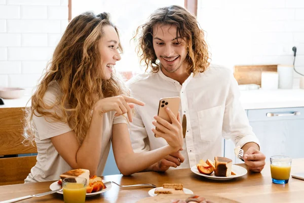 Щаслива Красива Пара Посміхається Використовує Мобільний Телефон Під Час Сніданку — стокове фото