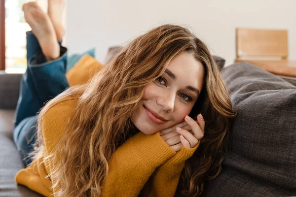 Gadis Cantik Yang Gembira Tersenyum Depan Kamera Sambil Berbaring Sofa — Stok Foto