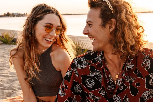 Sahilde birbirine bakan mutlu, pozitif, genç bir çiftin görüntüsü.