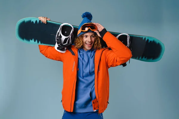 Guapo Deportista Feliz Sosteniendo Snowboard Aislado Sobre Fondo Azul — Foto de Stock