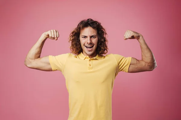 Zachwycony Przystojny Facet Uśmiecha Się Pokazuje Swoje Bicepsy Izolowane Różowym — Zdjęcie stockowe