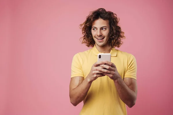 Porträtt Upphetsad Ung Man Med Mobiltelefon Isolerad Över Rosa Bakgrund — Stockfoto