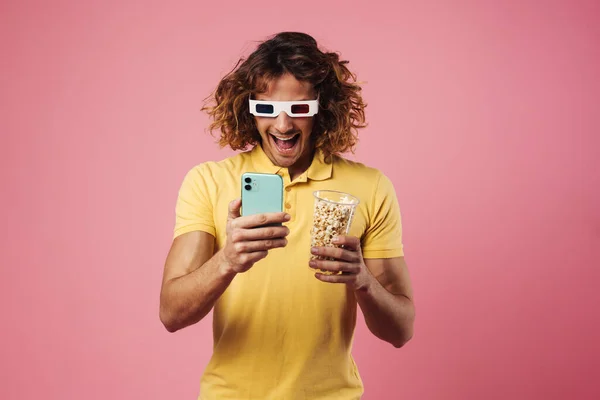 Excited Handsome Guy Glasses Eating Popcorn While Using Cellphone Isolated — Stock Photo, Image